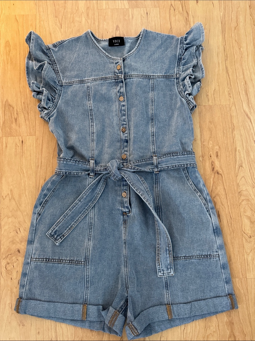 Vici Light Blue Denim Tie-Waist “Rudi” Romper with Ruffle Sleeves